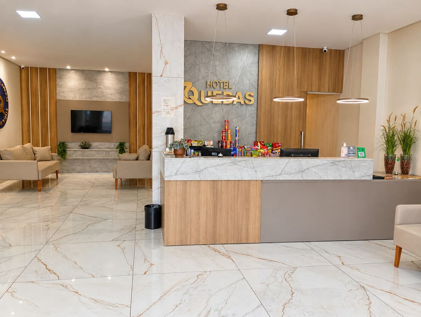 Recepção do Hotel 7 Quedas com balcão de mármore, letreiro dourado e sala de estar